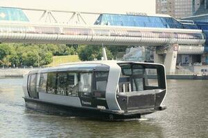 waterbus boot Aan moskee rivier. elektrisch schip Bij Moskou openbaar vervoer. ecologisch technologie. groen energie in stad route. dagelijks passagier veerboot onderhoud. Moskou, Rusland - juni 22, 2023. foto