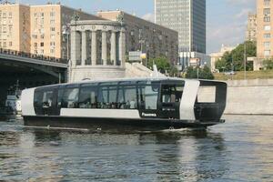 waterbus boot Aan moskee rivier. elektrisch schip Bij Moskou openbaar vervoer. ecologisch technologie. groen energie in stad route. dagelijks passagier veerboot onderhoud. Moskou, Rusland - juni 22, 2023. foto