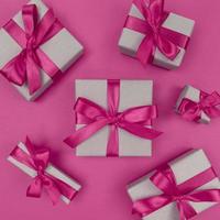 geschenkdozen verpakt in ambachtelijk papier met roze linten en strikken feestelijk zwart-wit plat gelegd