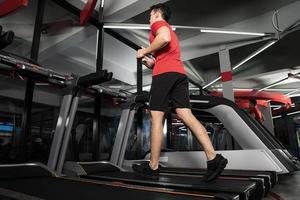 atletische jonge man loopt in de sportschool sport fitness training foto