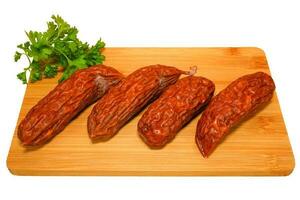 gerookt worstjes Aan houten snijdend bord met peterselie. vlees samenstelling. foto