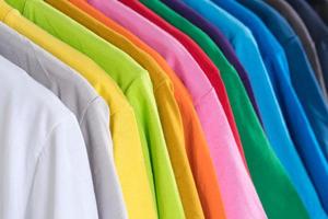 close-up van t-shirts kleding op hangers op witte achtergrond foto
