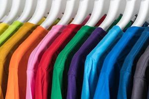 close-up van t-shirts kleding op hangers op witte achtergrond foto