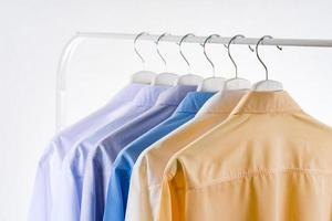 mannen overhemden kleding op hangers op witte achtergrond foto