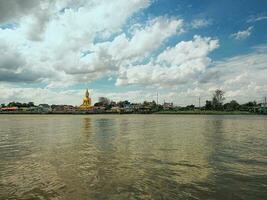 groot Boeddha standbeeld in een rivieroever tempel foto