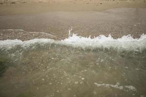 turkooizen golven van een woeste oceaan op het zomerstrand foto