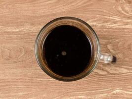 een kop van zwart koffie in een Doorzichtig glas met een visie van bovenstaand foto