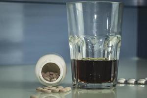 pillen zijn verspreid over de tafel whisky- of rumbehandeling of zelfmoord