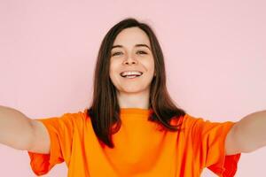 levendig sociaal media verhaal vertellen. mooi en blij vrouw in kleurrijk kleding, opname Instagram, Twitter post - influencer en informant concept, geïsoleerd Aan roze achtergrond. foto