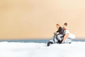 miniatuurmensen, gelukkig bruidspaar op een wit strand, huwelijksconcept foto