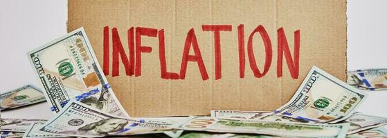 wereld inflatie concept. karton met woord inflatie en Amerikaanse Dollar bankbiljetten foto