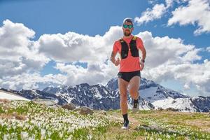sterke trailrunning atleet in de bergen in training foto