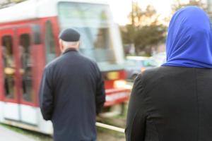 moslimvrouw die op een tram wacht