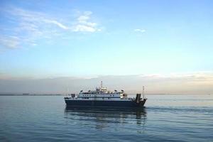 veerboot op de achtergrond van het zeegezicht in de avond foto