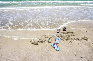 pantoffels met liefde handgeschreven op het strand foto