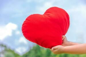 rood hert in hand- met lucht bule, rood hart, Valentijn hert simbol foto