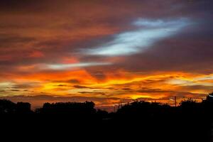 kleurrijk rood, blauw, en geel lucht in de avond in een landelijk Oppervlakte in Thailand, wanneer de zon heeft set, is een panoramisch visie van de warmte. heet, heet en eng foto