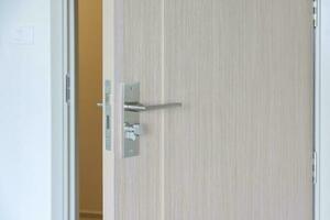 detailopname deurknop van houten deur tussen Open of dichtbij de deur foto