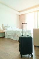 zwart bagage in modern hotel kamer na deur opening. bagage voor tijd naar reis, onderhoud, reis, reis, zomer vakantie en vakantie concepten foto