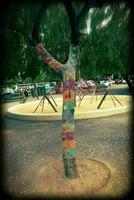 bomen in de park gekleed in handgemaakt haken kleurrijk formeel sjaals foto