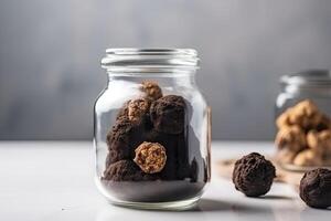 chocola truffels in een glas pot Aan een grijs achtergrond, heerlijk truffel taart detailopname binnen een glas kan, ai gegenereerd foto