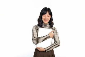 mooi jong Aziatisch vrouw Aan trui kleding Holding laptop pc computer en op zoek Bij camera met glimlach gezicht, geïsoleerd Aan wit achtergrond foto