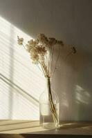 droog weide gras boeket in Doorzichtig glas fles esthetisch zon licht schaduwen Aan neutrale muur, minimalistische bloemen interieur ontwerp , genereren ai foto