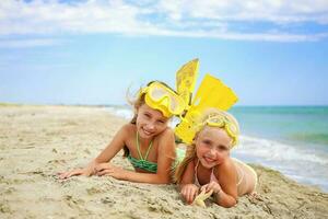 meisjes zonnen Aan strand in masker en vinnen voor scuba duiken. foto