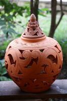 een inheems Thais pottenbakkerij klei in pot vorm geven aan, retro stijl en deksel voor versieren tuin Aan hout bord. foto