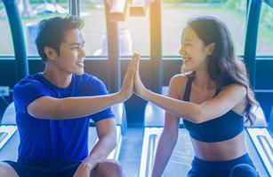 paar jonge mensen glimlachen ontspannen na training in de sportschool gezonde oefeningsconcepten foto