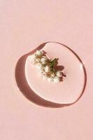 een laten vallen van kunstmatig gel met bloem Aan een roze achtergrond. foto