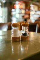 de zout en peper schudders zijn Aan de tafel in een bar of cafe. foto