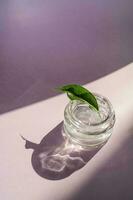 transparant gel in een pot Aan een lila achtergrond. foto