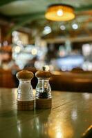 de zout en peper schudders zijn Aan de tafel in een bar of cafe. foto