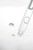 pipet met kunstmatig Product in water met bubbels. foto