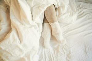 poten in warm leggings en wol sokken kijkje uit van onder de deken. foto