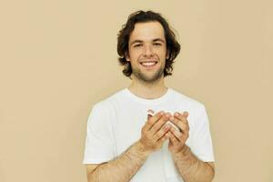 knap Mens in een wit t-shirt met een mok in hand- geïsoleerd achtergrond foto