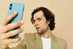 Mens in een pak poseren emoties op zoek Bij de telefoon geïsoleerd achtergrond foto