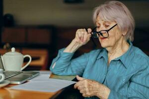 gelukkig senior vrouw in een cafe een kop van drinken laptop sociaal netwerken ongewijzigd foto