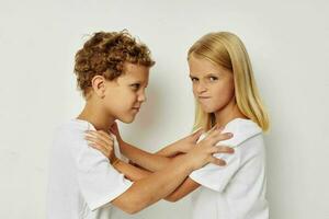 foto van twee kinderen in wit t-shirts zijn staand De volgende naar beige achtergrond