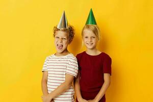 jongen en meisje glimlachen en poseren in gewoontjes kleren tegen Aan gekleurde achtergrond foto