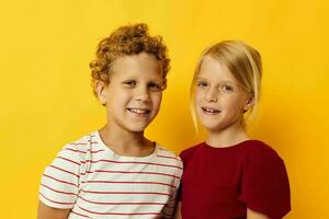 jongen en meisje staand kant door kant poseren kinderjaren emoties geïsoleerd achtergrond foto