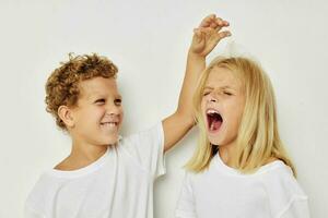 schattig elegant kinderen in wit t-shirts zijn staand De volgende naar levensstijl ongewijzigd foto