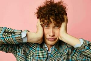 vent met rood gekruld haar- in een pak bedrijf kijken poseren emoties roze achtergrond ongewijzigd foto