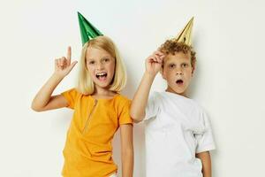 twee blij kinderen poseren emoties vakantie kleurrijk petten licht achtergrond foto