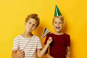 afbeelding van positief jongen en meisje vakantie pret met petten Aan uw hoofd geïsoleerd achtergrond foto