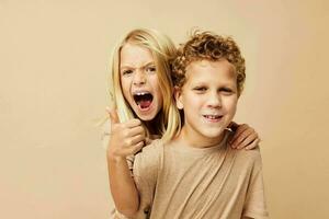 portret van schattig kinderen in beige t-shirts poseren voor pret geïsoleerd achtergrond foto