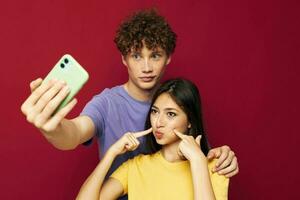 Mens en vrouw modern stijl emoties pret telefoon rood achtergrond foto