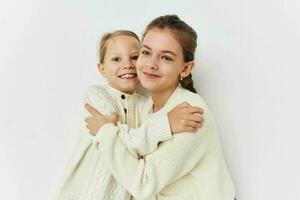 twee weinig meisjes vriendinnetjes poseren licht achtergrond foto