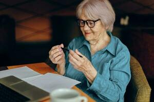 senior vrouw werken in voorkant van laptop toezicht houden op zittend gepensioneerd vrouw chatten ongewijzigd foto